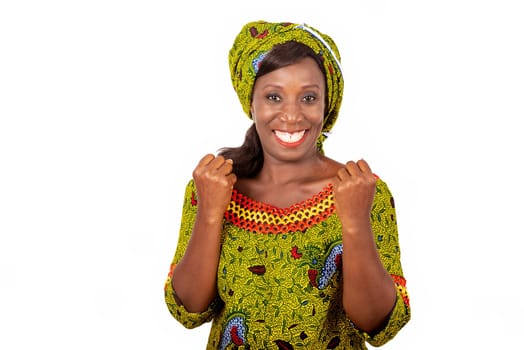beautiful African adult woman dressed in green loincloth shows her victory by raising both arms