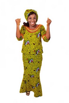 beautiful african adult woman under a magnificent suit of green loincloth is all joyful by raising both arms