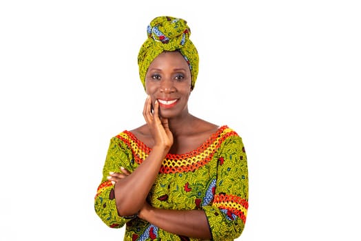 beautiful African adult woman dressed in green loincloth is smiling with arms crossed and hand raised on the cheek