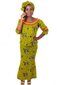 beautiful African adult woman wearing a green loincloth with heels on the feet is smiling on the phone while being arrested