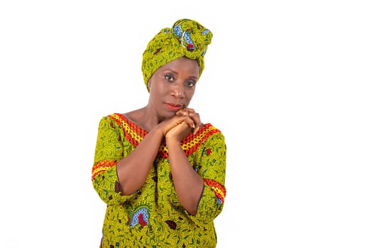 Beautiful african adult woman wearing a loincloth and scarf with green head on isolated white background posing both hands together
