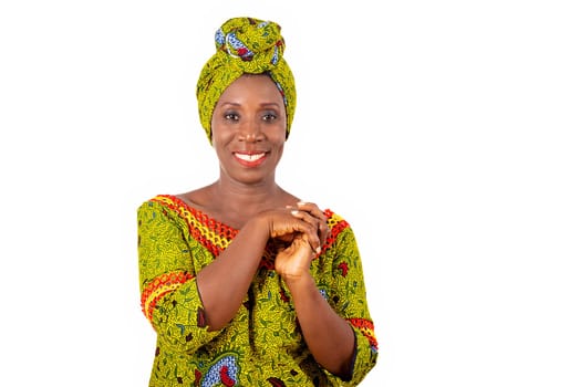 Beautiful african adult woman wearing a loincloth and scarf with green head on isolated white background posing both hands together smiling