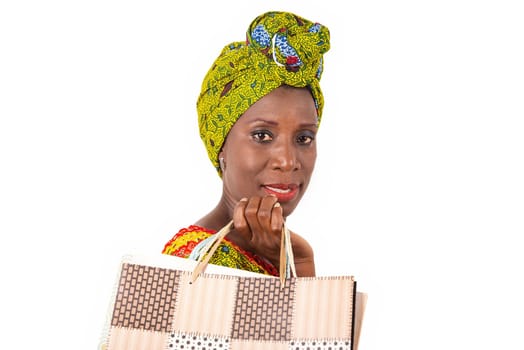 beautiful african adult woman wearing a loincloth and a green scarf is happy with shopping bags in hand