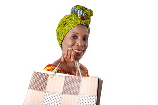 beautiful african adult woman wearing a loincloth and a green scarf is happy with shopping bags in hand