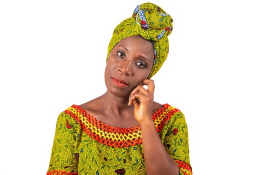 beautiful african adult woman wearing a loincloth and a green scarf is thinking with the hand on the chin