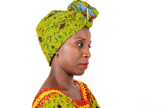side view of a beautiful African adult woman under a loincloth and green scarf in the head is thinking about