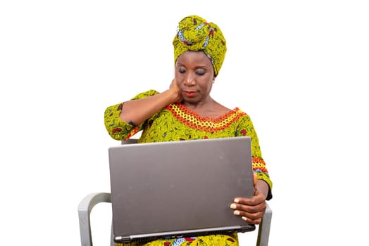 beautiful mature woman sitting in traditional dress on white background looking at laptop.