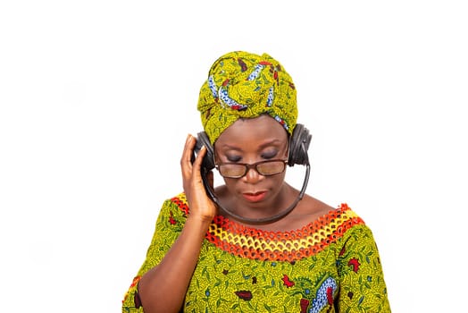 beautiful mature woman in eyeglasses isolated on white background communicating using headphones.