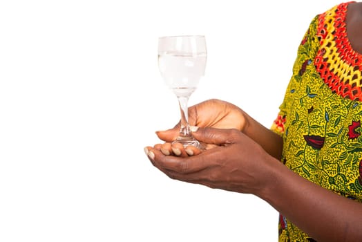 African adult female hand holding a glass of clear water. A glass of clean mineral water in the hands, healthy drink.