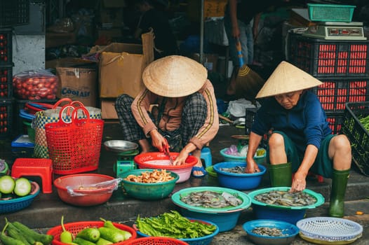 Vietnamese women sellers at the Asian street food market in the old town in Hoi An in Vietnam in Asia. Hoi An, Vietnam - December 2, 2024