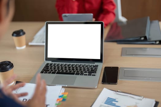 A well-organized office workspace showcases laptops and financial documents, illustrating a productive environment for collaborative work and planning.