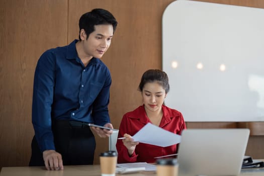 Two colleagues diligently analyze financial documents and charts, discussing important insights during their meeting, emphasizing data-driven decision-making.