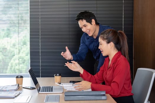 In a modern office, two professionals analyze financial data while brainstorming strategies for business growth.