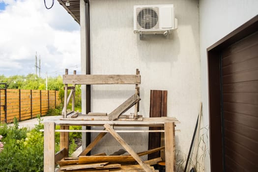 Wooden frames under white air conditioner. Practical home improvement and resourceful construction methods and care.