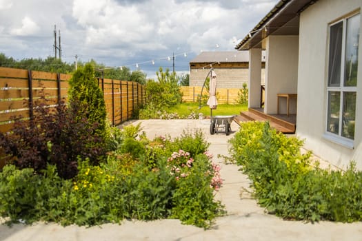 Green yard behind wooden fence. Organized outdoor living showing practical space usage and plant arrangement