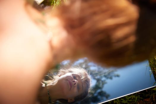 Fairy princess in a beautiful dress, laying on the forest floor, reflected in a mirror. Environmental friendliness and caring for nature