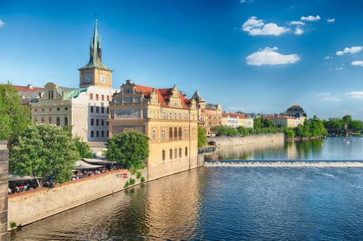 Panoramic view of Vltava River with tour boats and historic architecture in Prague, Czech Republic