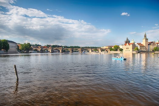 Charles Bridge crossing the Vltava River on a sunny day with the buildings of old town in the background in Prague, Czech Republic