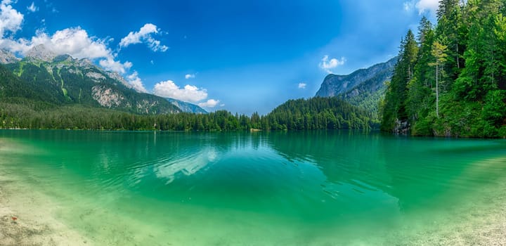 Panoramic view of the beautiful Lake Tovel with the Brenta Dolomites in the background on a sunny summer day, Trentino Alto Adige, Italy
