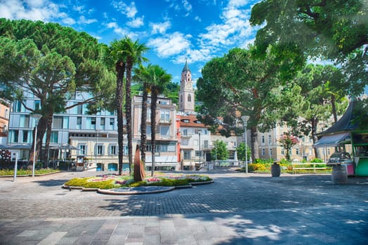 A sunny day walking down a pedestrian street lined with shops and restaurants in Merano, South Tyrol, Italy