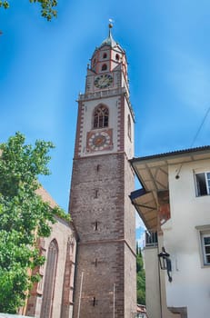 Clocktower of St. Nicholas Church, one of the main buildings and landmarks in the city of Merano, South Tyrol, Italy