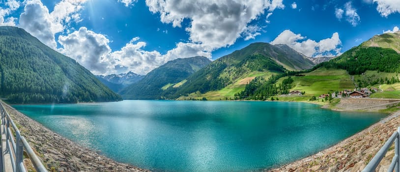 Turquoise water reflecting the blue sky of a sunny summer day at Lake Vernago in Trentino Alto Adige, Italy