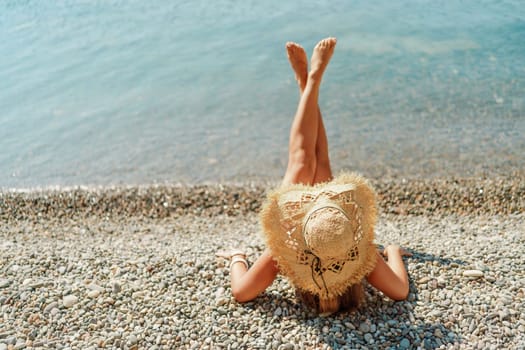 Beach Relaxation woman lies on a pebble beach, legs raised, and arms spread out. The concept of travel, vacation at sea.