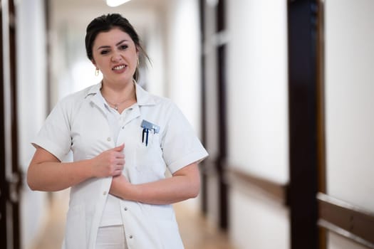 A dedicated nurse in uniform walks briskly down a well-lit hospital corridor, reflecting professionalism and urgency in a healthcare setting