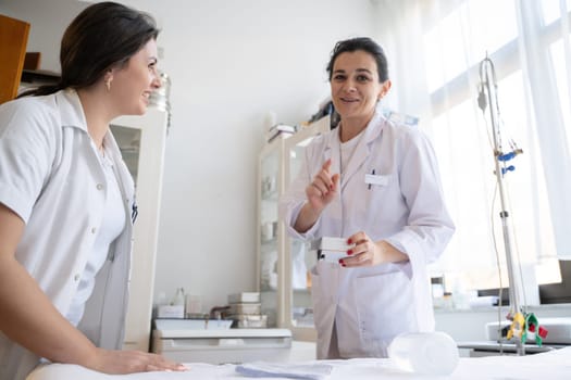 Two nurses in a hospital laboratory are carefully inspecting and preparing medications for patients and hospital use