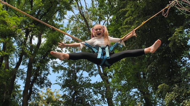 Teenage girl silhouette jumping on the trampoline bungee jumping
