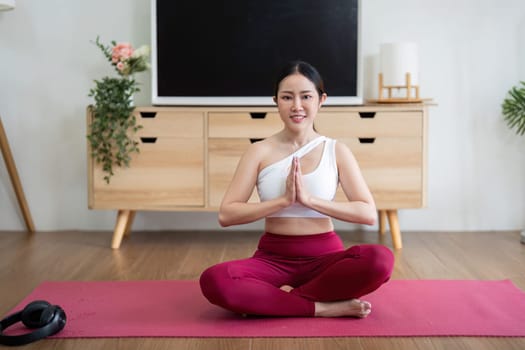 In a tranquil setting, a woman sits in a traditional yoga pose, emphasizing calmness and mindfulness, connecting deeply with her practice.