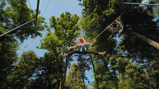 Teenage girl jumping on the trampoline bungee
