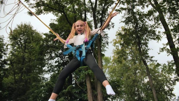 Teenage girl jumping on the trampoline bungee