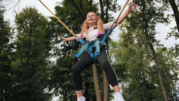 Teenage girl jumping on the trampoline bungee