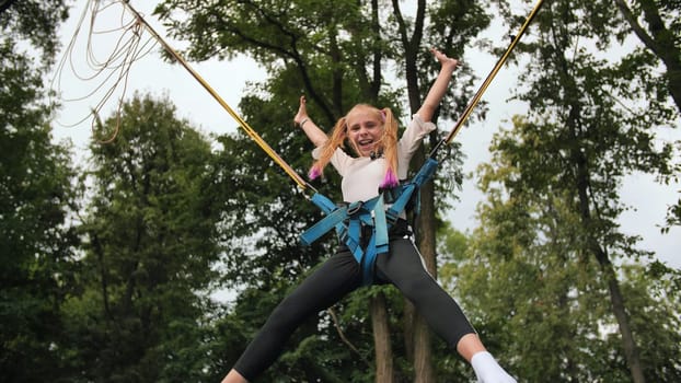 Teenage girl jumping on the trampoline bungee
