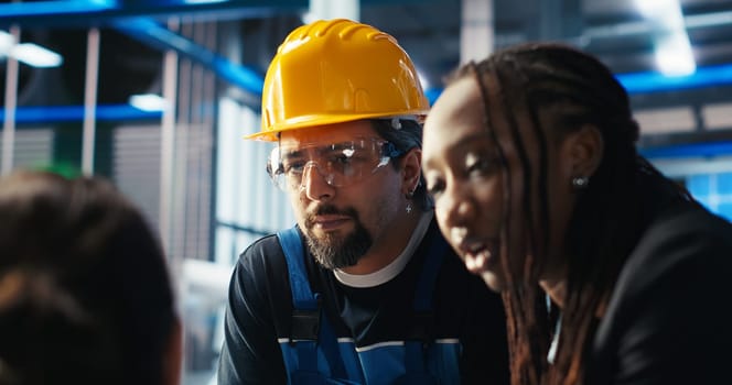 Photovoltaics factory manager giving tasks to workers, asking them to adjust system parameters. Team leader telling employees how to optimize energy supply in solar panel manufacturing plant, camera B