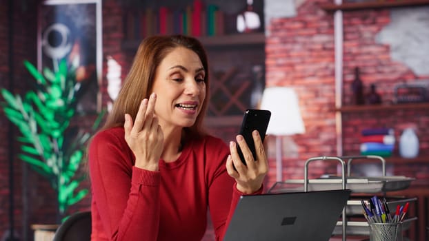 Mature woman engaging in virtual workshop to learn new skills for job, interacting with the coach. Ambitious person joining interactive web learning session for personal development. Camera A.