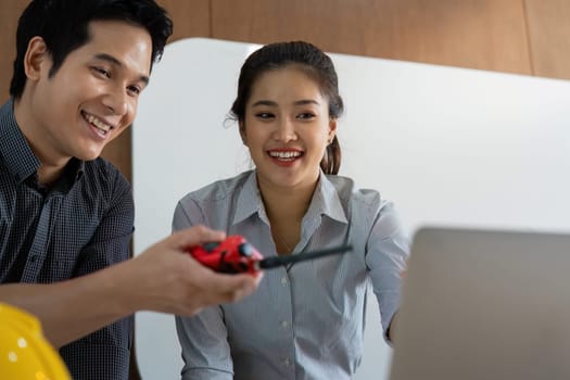 A friendly exchange between two engineers highlights the importance of teamwork. Their use of technology illustrates modern engineering practices in project coordination.