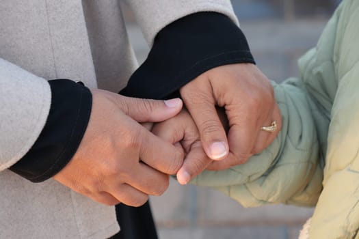mother hold hands her child in a warm gesture of affection,