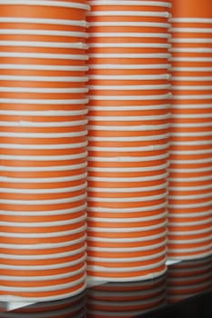 Bright orange cups are neatly stacked together in a vibrant cafe.