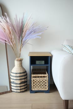 This cozy living room corner features a stylish flower arrangement and a clock.