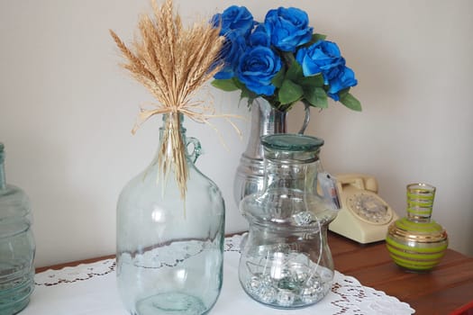 Beautifully arranged glass bottles and faux flowers enhance home decor.