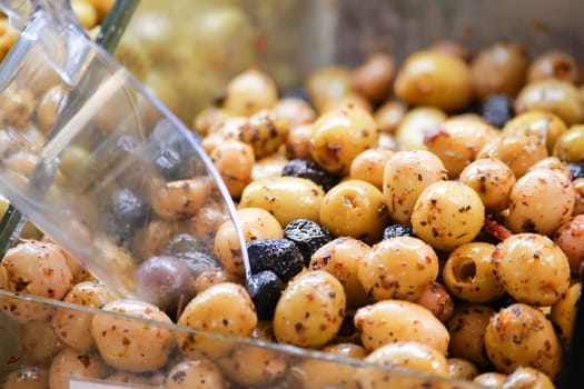 Cured olives displayed for purchase, showcasing various colors and flavors.