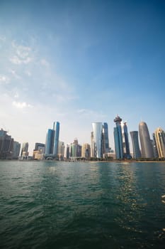 A sunny day showcases a modern skyline along the waterfront.