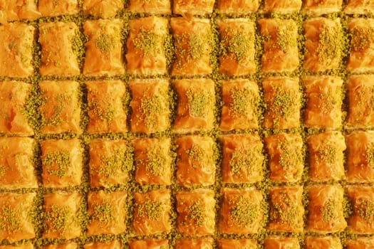 Rows of sweet baklava topped with pistachios attract market visitors.