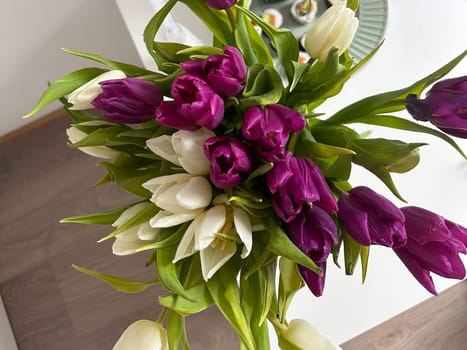 Tulip bouquet in hand with soft natural light and festive wrapping. Seasonal flower gifting and emotional expression at home