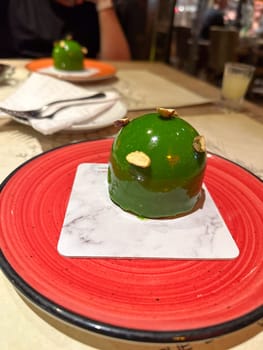 Modern dessert served on red plate in restaurant setting. Represents indulgence, culinary art, and the joy of shared dining experiences