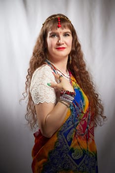 In a creatively lit space, a woman showcases her vibrant sari adorned with jewelry, embodying a blend of heritage and contemporary lifestyle.