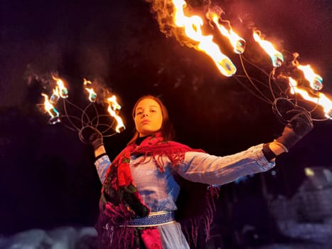 Breathtaking performance showcases brave actors in ethnic costumes wielding fire, creating a mesmerizing spectacle on a cold winter night.