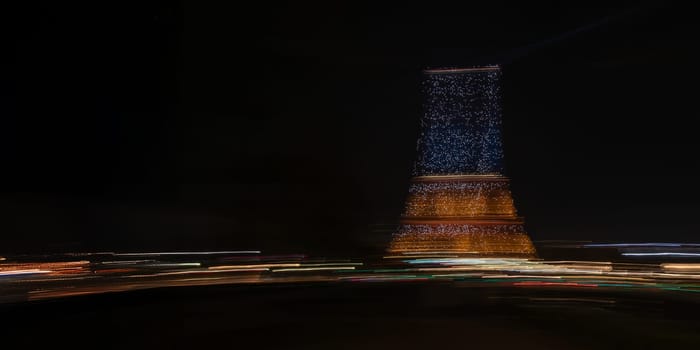 Paris, France - February 24, 2025: the view of illuminated Eiffel Tower at night as streaks of light fill the scene, captured in motion with long exposure. Creative dynamic romantic background